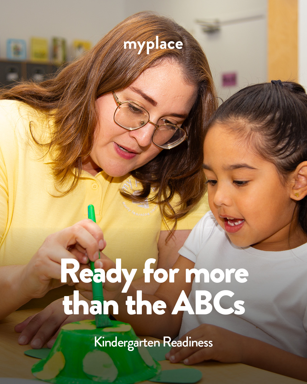 A MyPlace Early Learning Center teacher helps a preschool child paint a craft project for a Kindergarten Readiness activity, Katy, TX