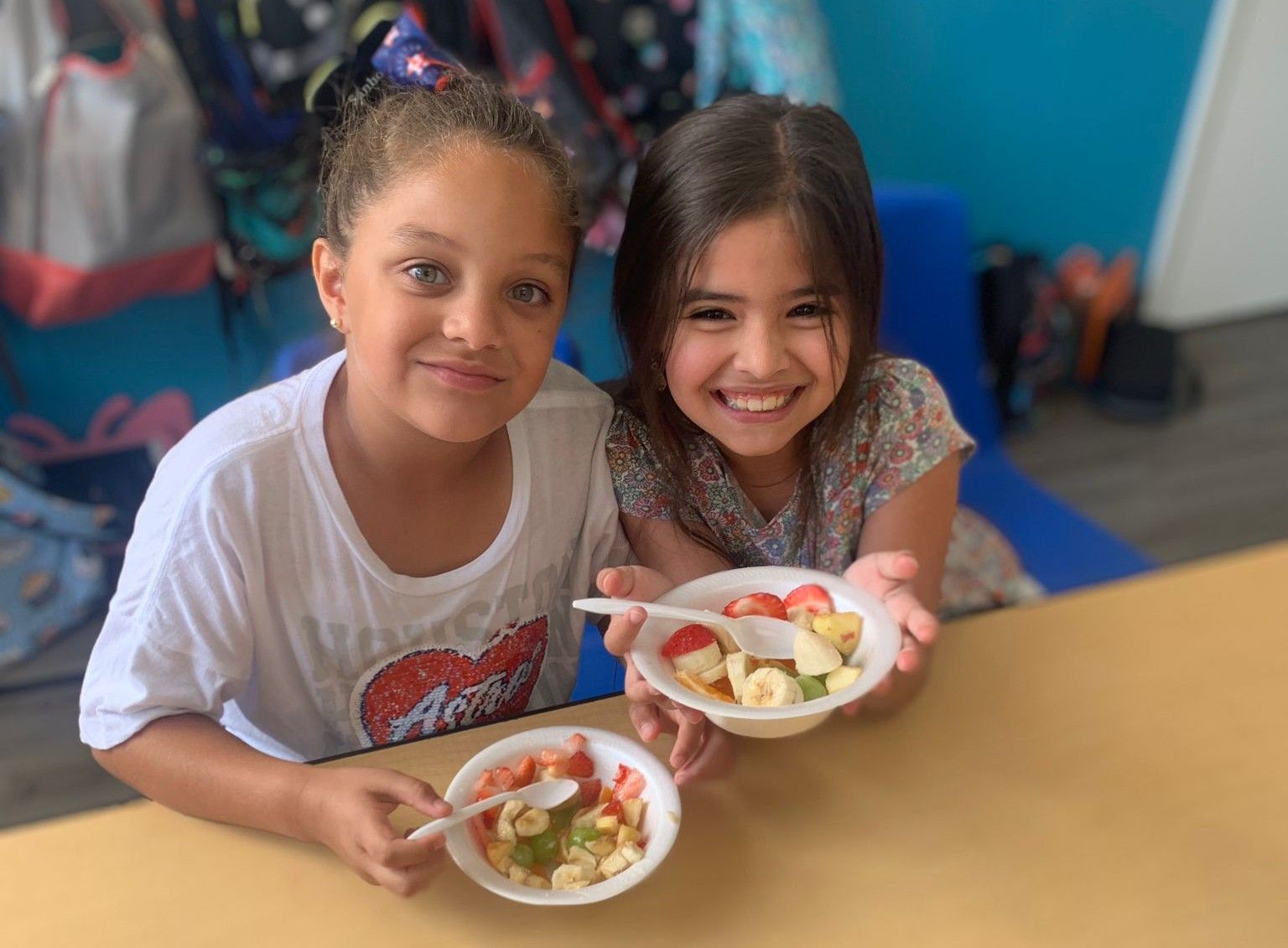 Two friends sharing fruit bowls at MyPlace