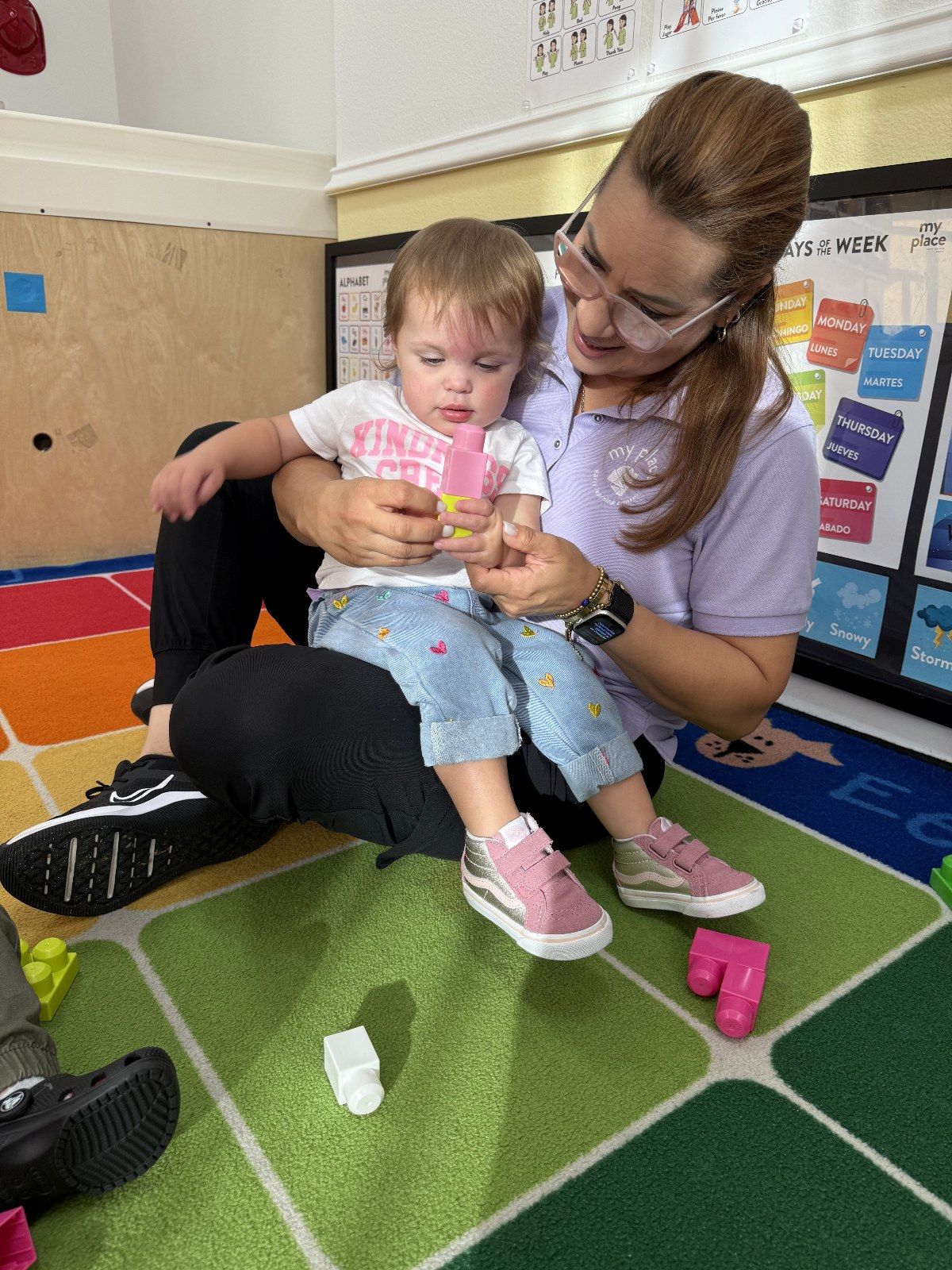 A MyPlace teacher playing blocks with a toddler
