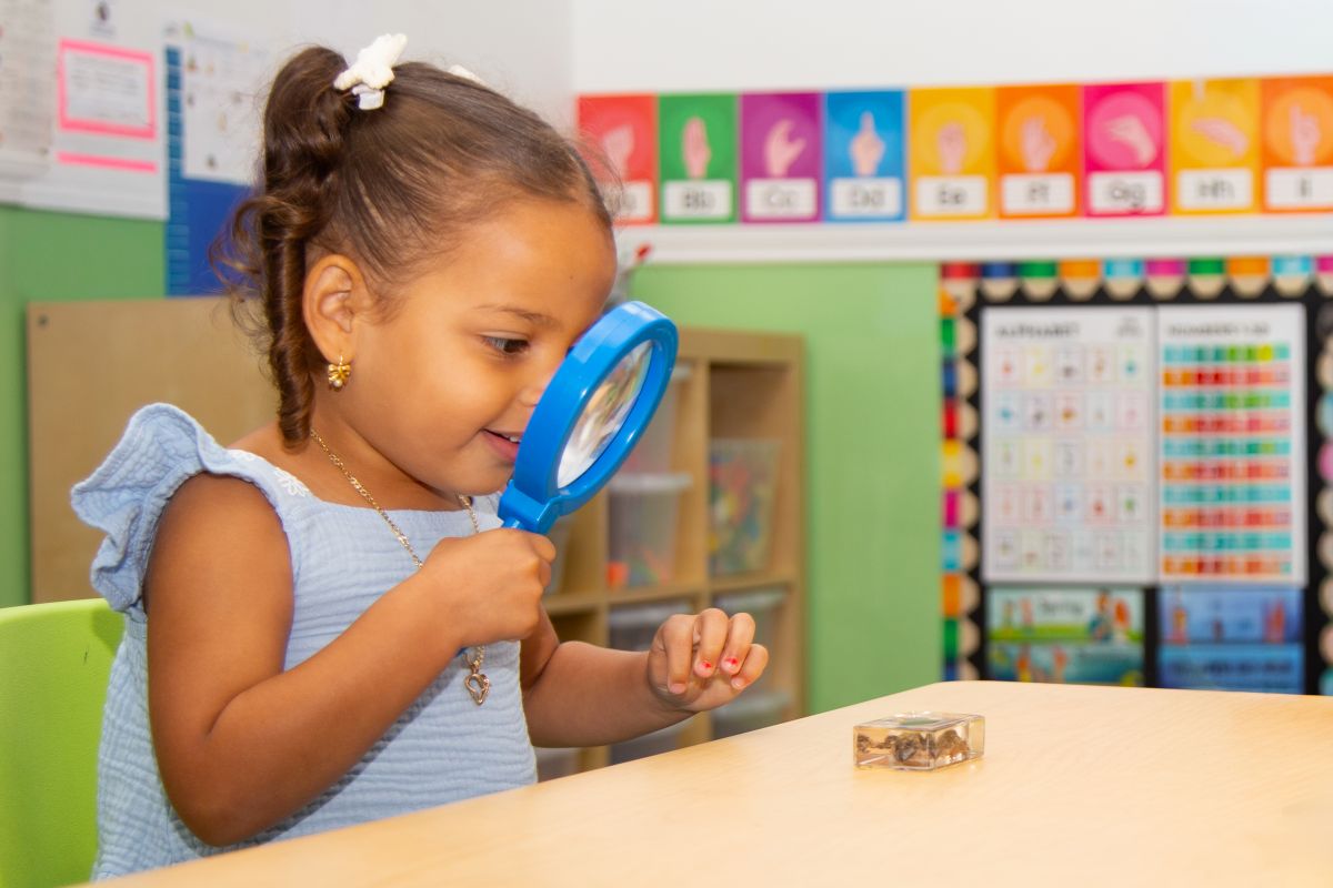 A preschooler exploring with a magnifying glass at MyPlace, Katy TX