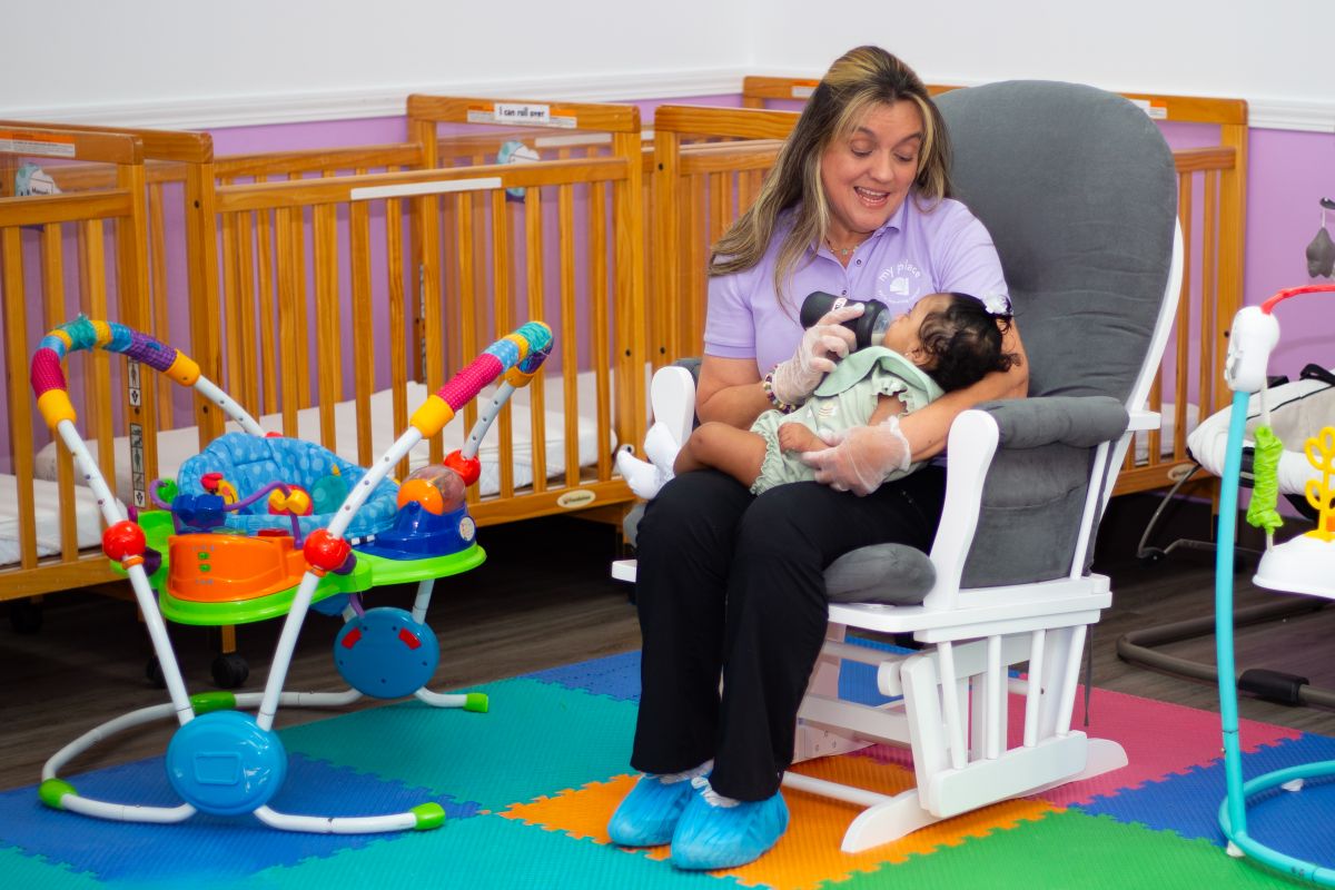 A teacher rocking an infant in the nursery at MyPlace, Katy TX