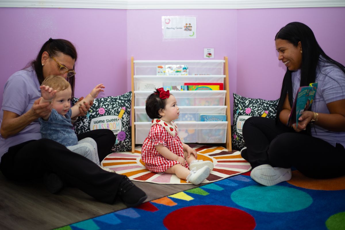 Teachers playing with an infant at MyPlace Early Learning Center, Katy TX