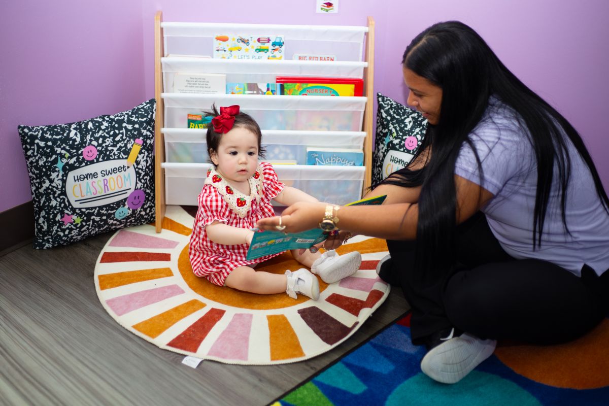 An infant enjoying story time with her teacher at MyPlace, Katy TX
